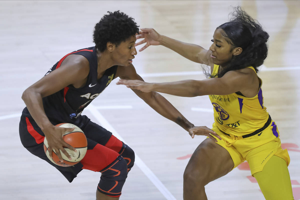 Las Vegas Aces' Angel McCoughtry, left, drives against Los Angeles Sparks' Te'a Cooper during t ...
