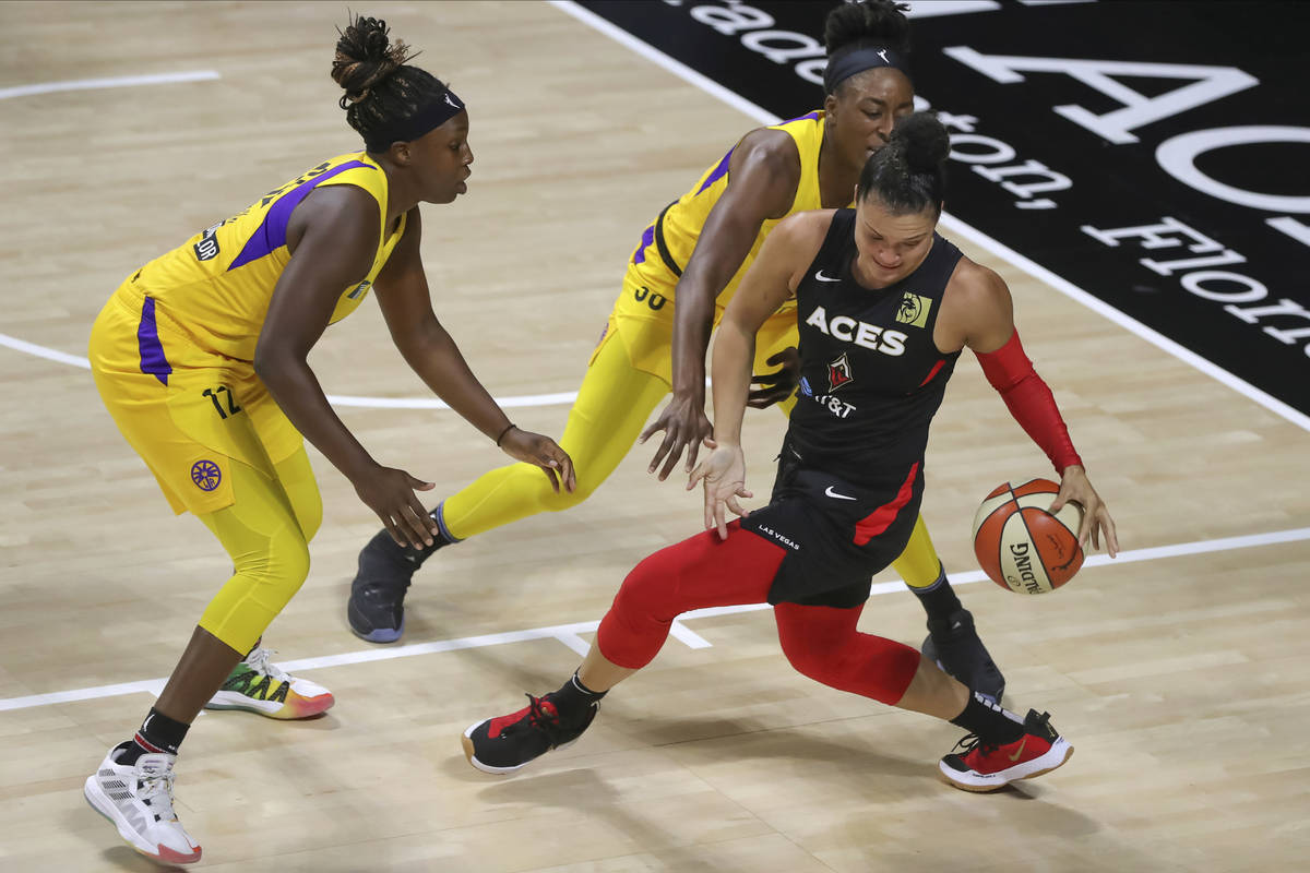 Las Vegas Aces' Kayla McBride, right, is defended by Los Angeles Sparks' Chelsea Gray (12) and ...