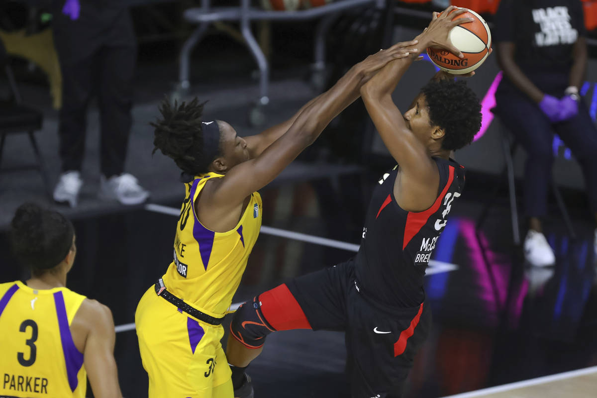 Los Angeles Sparks' Nneka Ogwumike, center, fouls Las Vegas Aces' Angel McCoughtry as Candace P ...