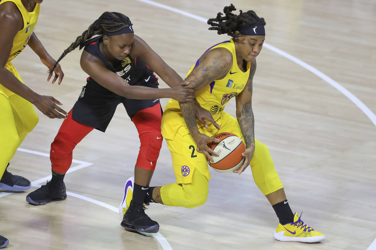 Las Vegas Aces' Sugar Rodgers, left, tries to steal the ball from Los Angeles Sparks' Riquna Wi ...