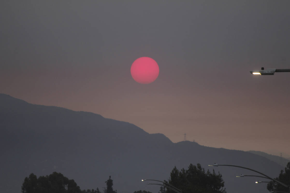 Smoke from wildfires burning east of Los Angeles dims the sunrise on Monday, Sept. 7, 2020, see ...