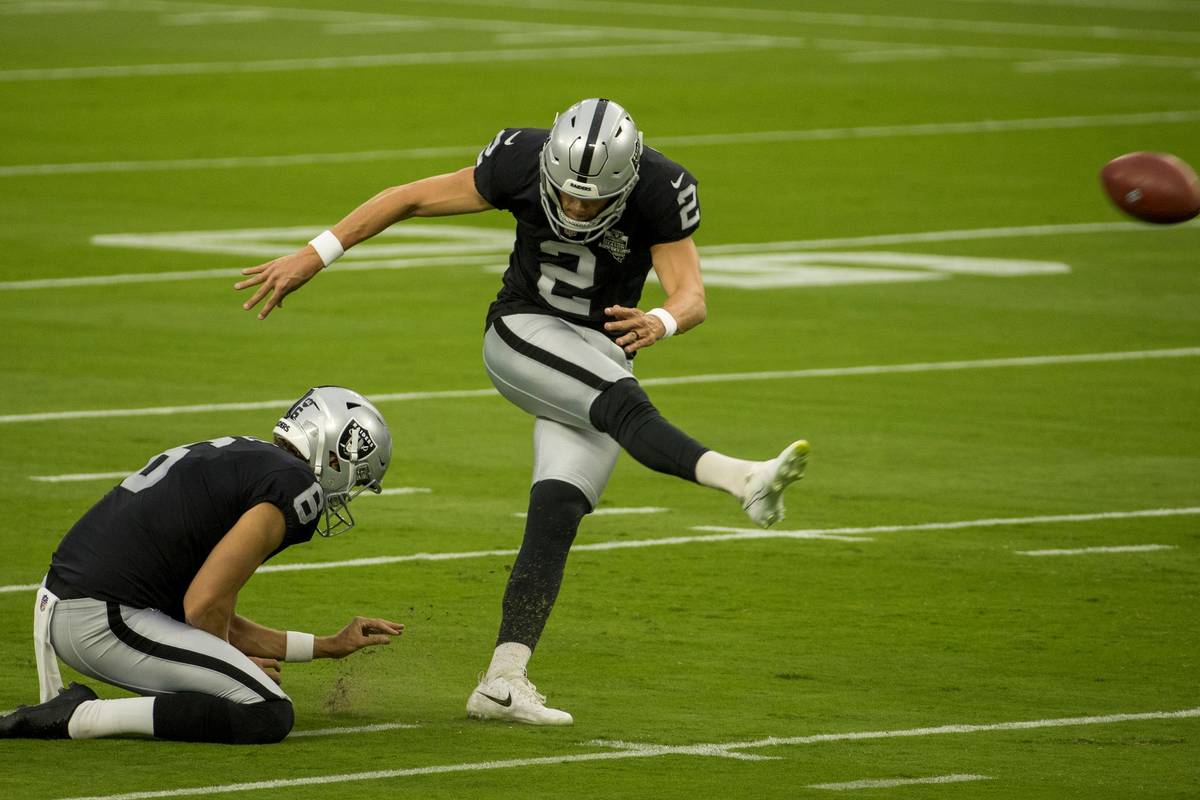 Las Vegas Raiders punter AJ Cole (6, left) holds the ball as place kicker Daniel Carlson (2) ge ...