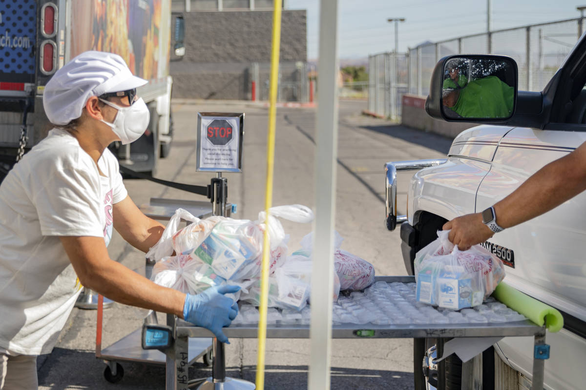 Food service manager of Basic Academy of International Studies, Yanina Cartellone, left, passes ...