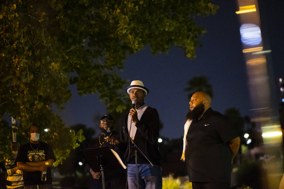 Minister Vance "Stretch" Sanders, center, speaks during a candlelight vigil for Jorge ...