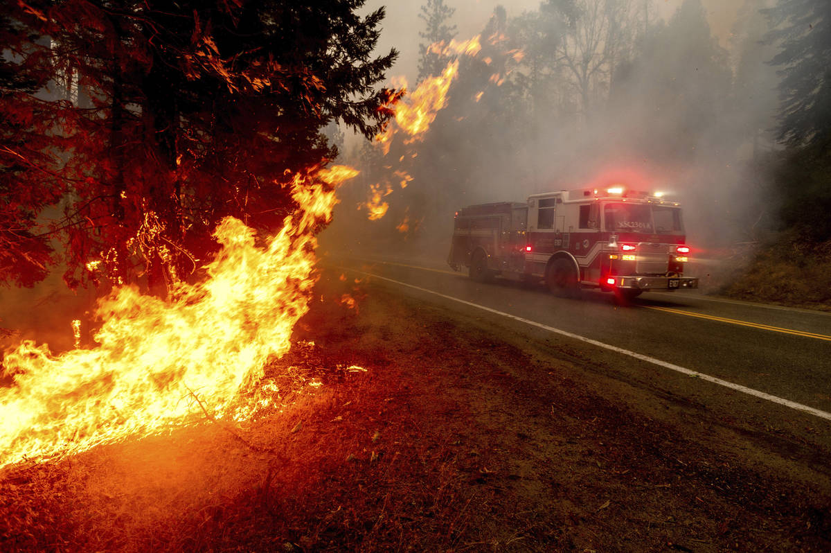 FILE - In this Sept. 7, 2020, file photo a firetruck drives along state Highway 168 while battl ...