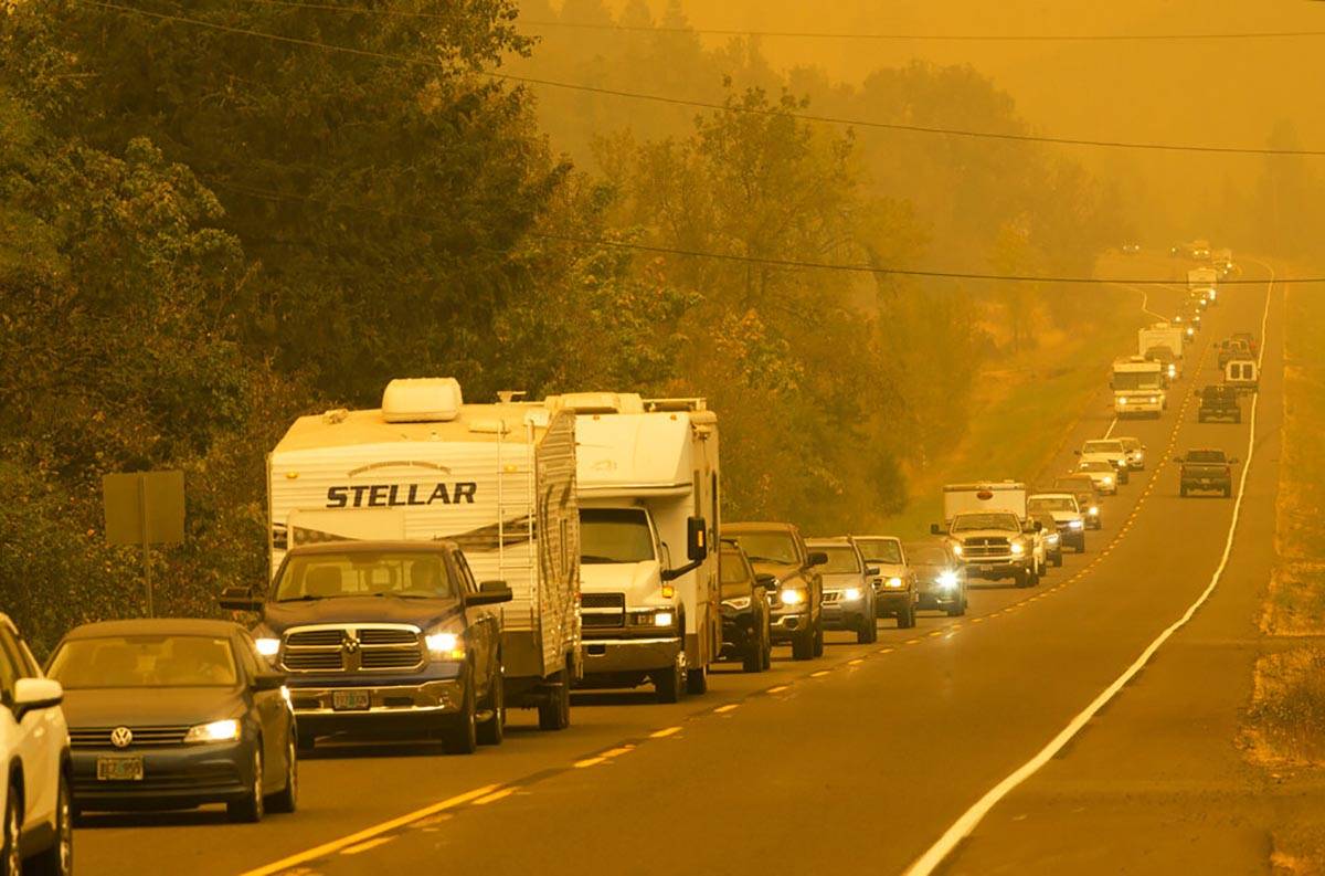 A steady stream of vehicles heads west on a road east of Springfield, Ore., as residents evacua ...