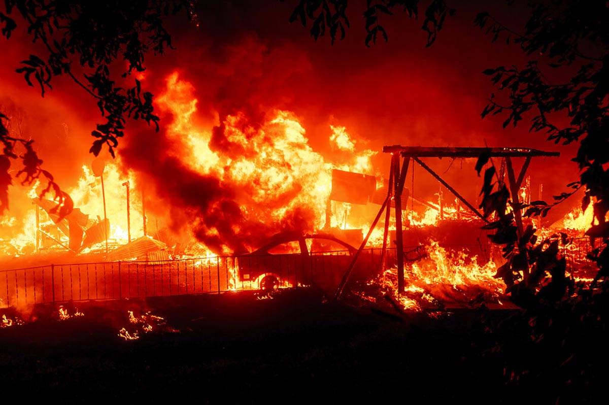 Flames consume a home and car as the Bear Fire burns through the Berry Creek area of Butte Coun ...