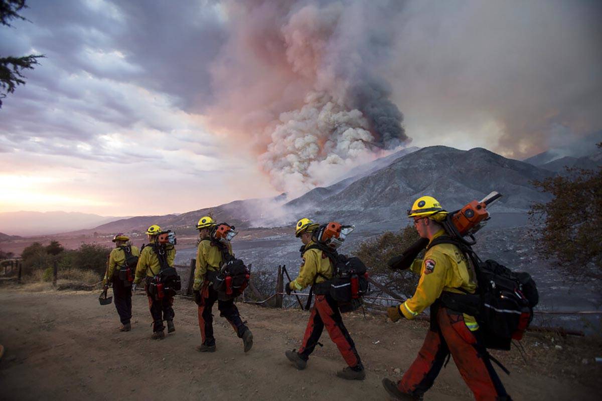 Members of firefighters walk in line during a wildfire in Yucaipa, Calif., Saturday, Sept. 5, 2 ...