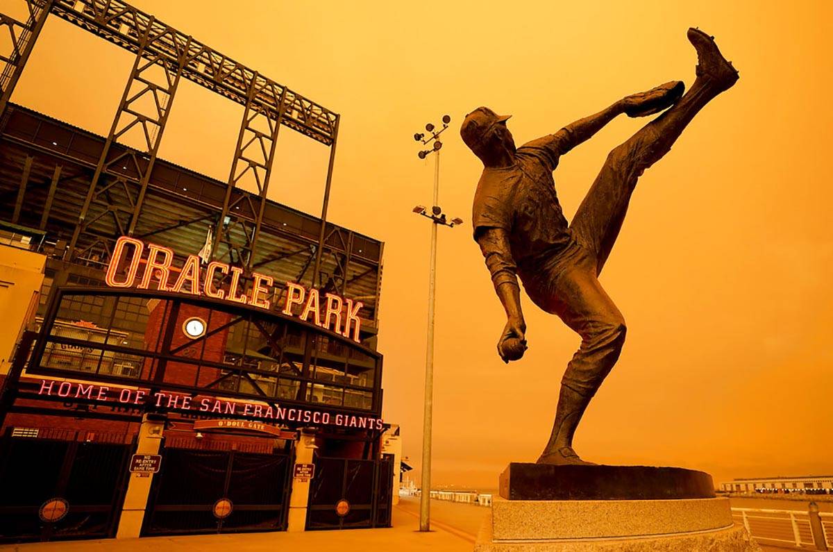 Wildfire smoke darkens the sky over a statue of former San Francisco Giants pitcher Juan Marich ...