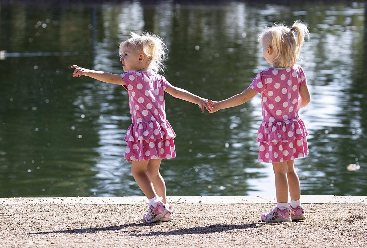 Eloise Agnew, 2, left, and her sister Penelope, 3, walk along Sunset Park pond on Thursday, Se ...