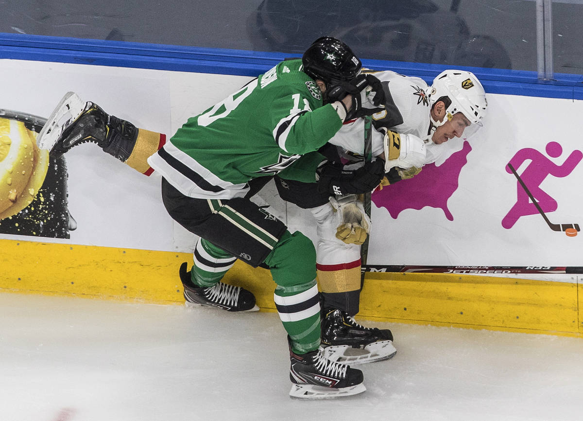 Dallas Stars center Jason Dickinson (18) checks Vegas Golden Knights center Tomas Nosek (92) du ...