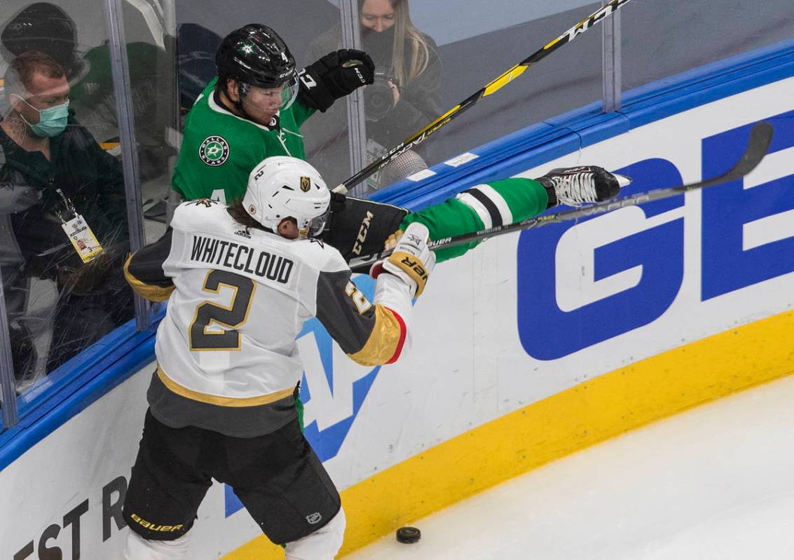 Dallas Stars' Miro Heiskanen (4) is checked by Vegas Golden Knights' Zach Whitecloud (2) during ...