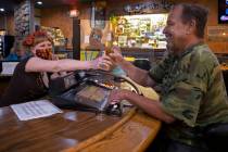 Bartender Teah Heath, left, serves a beer to Lyle Bogggess at Jackson’s Bar & Grill on Thursd ...