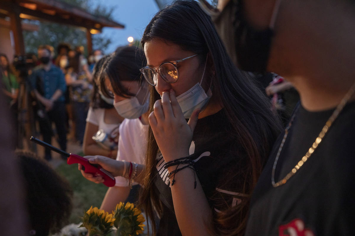Sister of victim Lesly Palacio, Nayelli Palacio, 16, wipes her tears while she lights candles d ...
