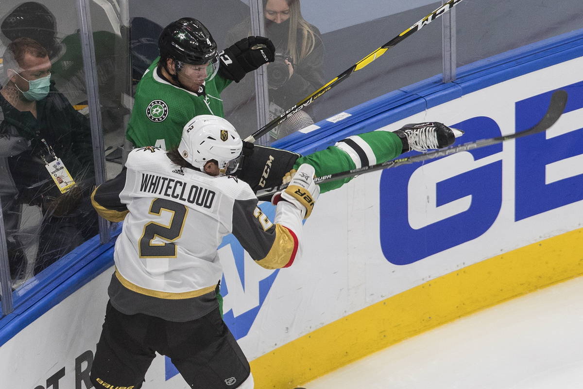 Dallas Stars' Miro Heiskanen (4) is checked by Vegas Golden Knights' Zach Whitecloud (2) during ...