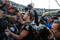 Oakland Raiders quarterback Derek Carr is greeted by fans in "The Black Hole" after a ...