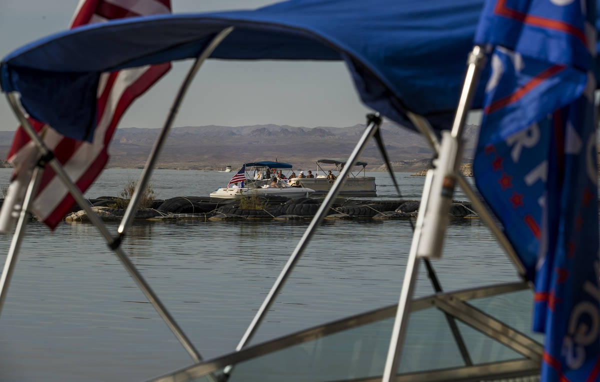Two boats pass as some boats are already prepared for the President Donald Trump boat parade Sa ...