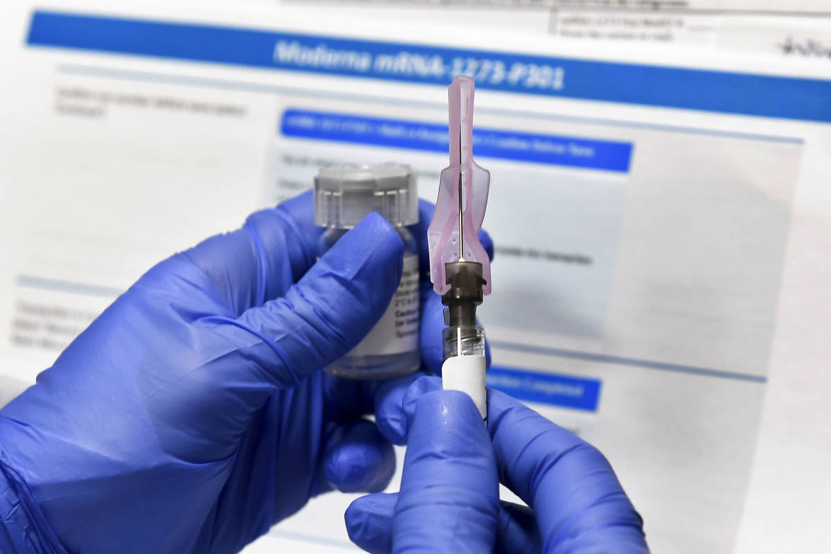 A nurse prepares a shot as a study of a possible COVID-19 vaccine, developed by the National In ...