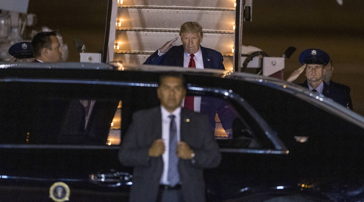 President Donald Trump arrives at McCarran International Airport and salutes after deplaning fr ...