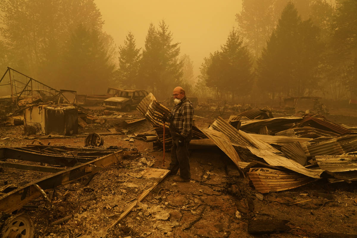 George Coble walks through what remains of a home on his property destroyed by a wildfire Satur ...