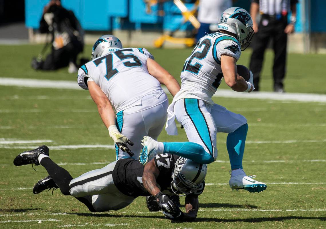 Carolina Panthers running back Christian McCaffrey (22) leaps over Las Vegas Raiders cornerback ...