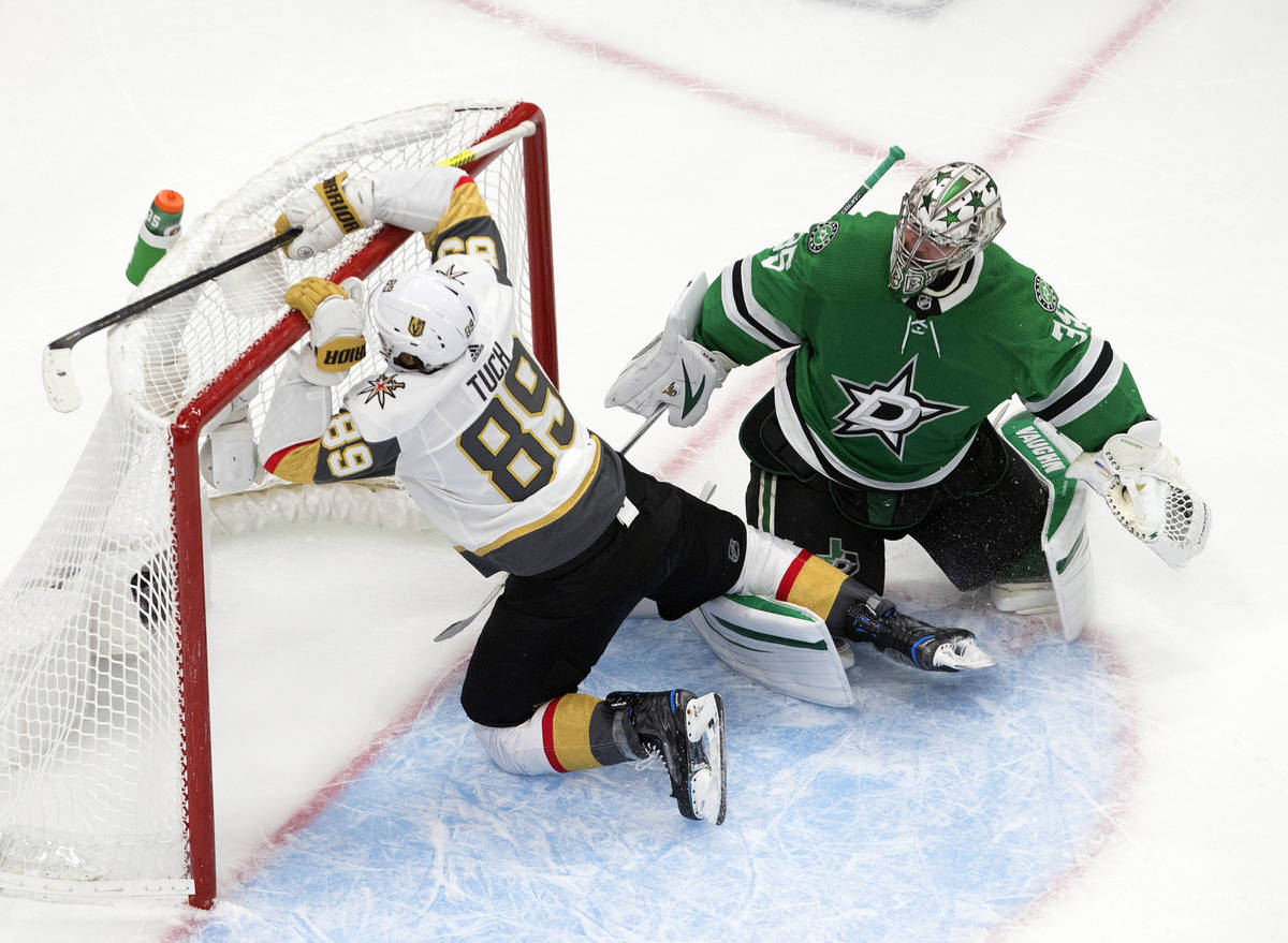 Dallas Stars goalie Anton Khudobin (35) watches as Vegas Golden Knights' Alex Tuch (89) crashes ...