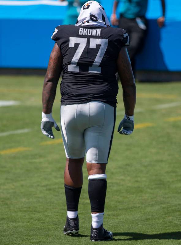 Las Vegas Raiders offensive tackle Trent Brown (77) walks off the field with a trainer after th ...