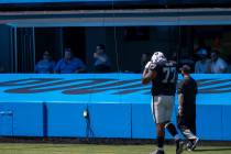 Las Vegas Raiders offensive tackle Trent Brown (77) walks off the field with a trainer after th ...