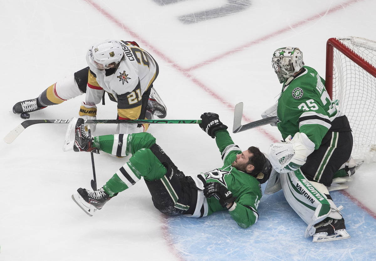 Dallas Stars goalie Anton Khudobin (35) makes a save as Vegas Golden Knights center Nick Cousin ...