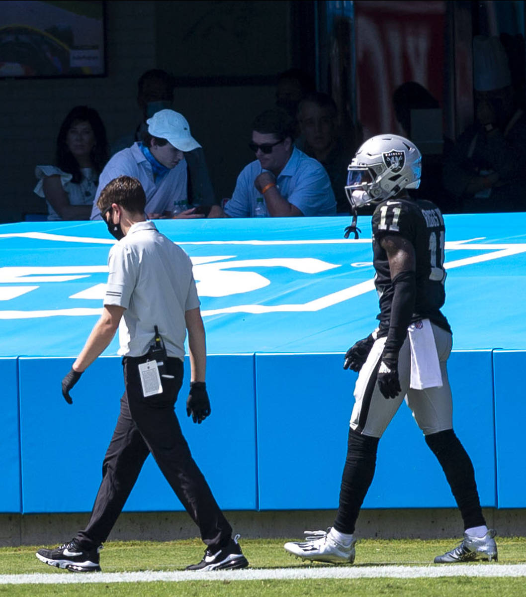 Las Vegas Raiders wide receiver Henry Ruggs III (11) walks off the field with a trainer in the ...