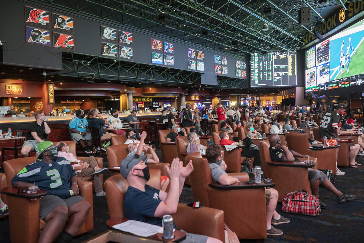 Individuals watch games at the Westgate Sportsbook during opening weekend, in Las Vegas on Sund ...