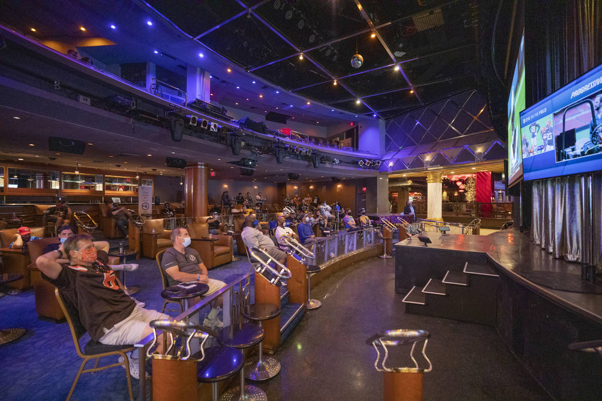 Individuals watch games while sitting six feet apart in the Westgate Cabaret, in Las Vegas on S ...