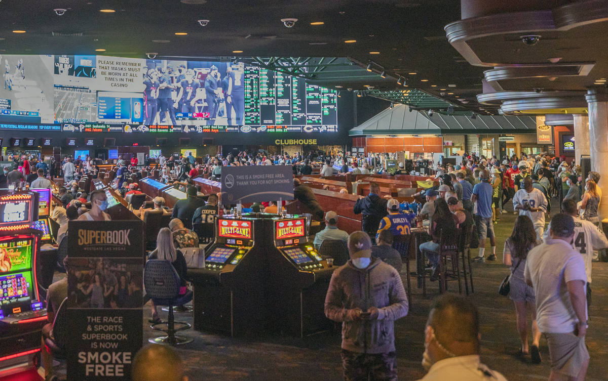 Individuals watch games at the Westgate Sportsbook during opening weekend, in Las Vegas on Sund ...