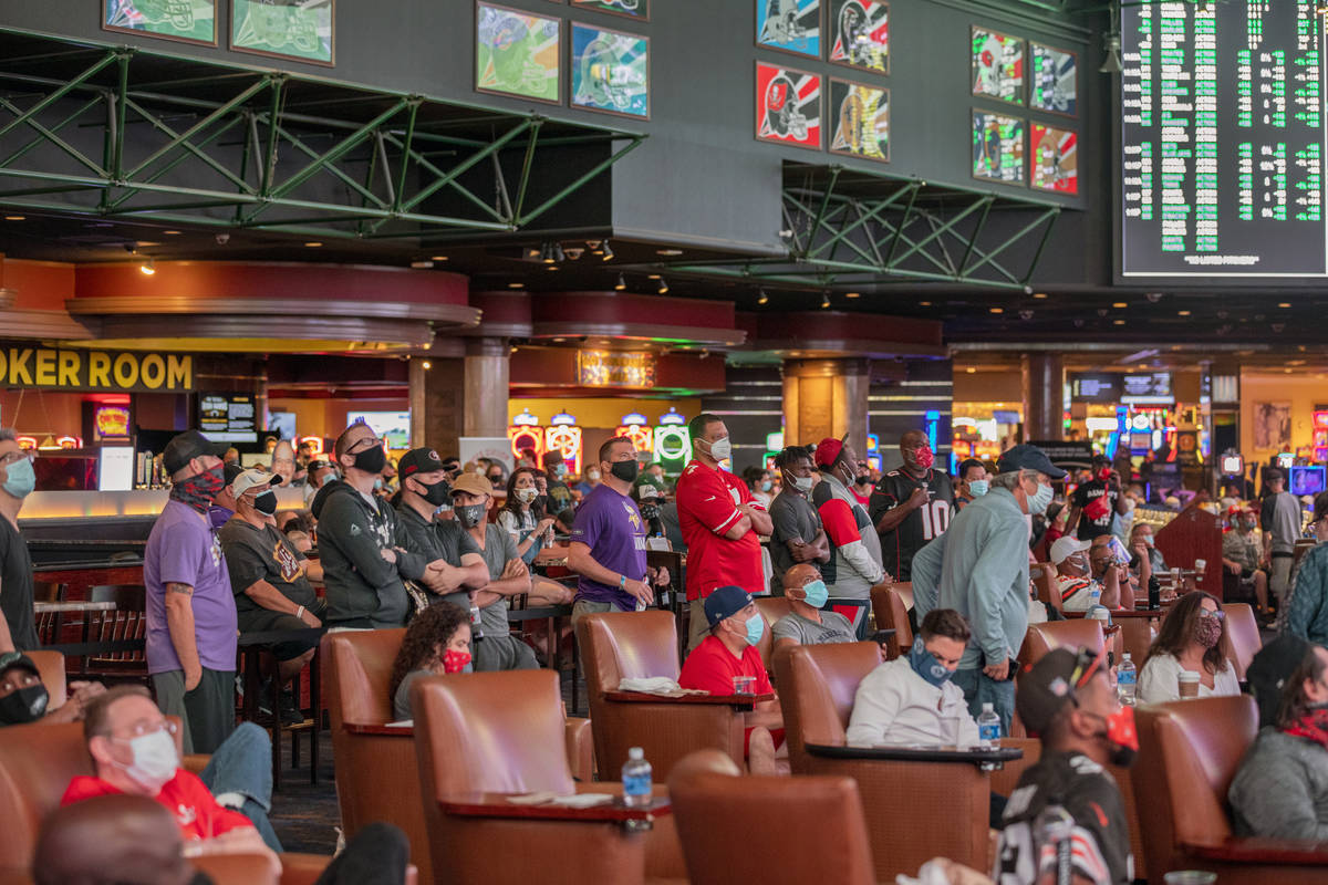 Individuals watch games at the Westgate Sportsbook during opening weekend, in Las Vegas on Sund ...