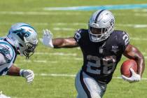 Las Vegas Raiders running back Josh Jacobs (28) stiff arms Carolina Panthers linebacker Brian B ...