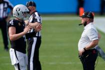 Las Vegas Raiders head coach Jon Gruden talks with quarterback Derek Carr during the second hal ...