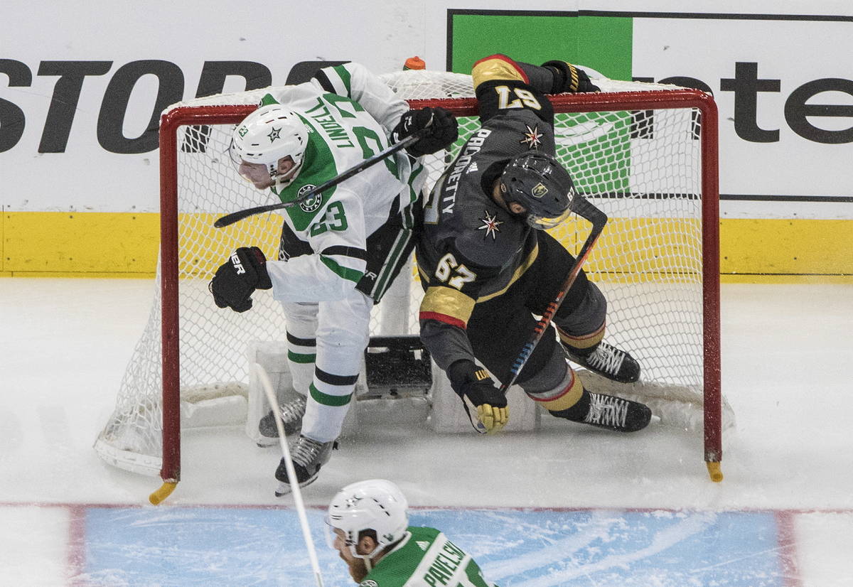 Dallas Stars' Esa Lindell (23) and Vegas Golden Knights' Max Pacioretty (67) crash into the net ...