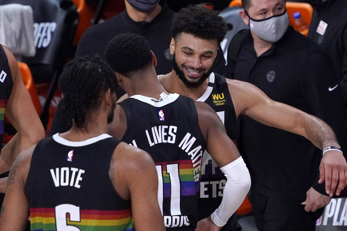 Denver Nuggets' Jamal Murray, right, celebrates with Monte Morris (11) after an NBA conference ...