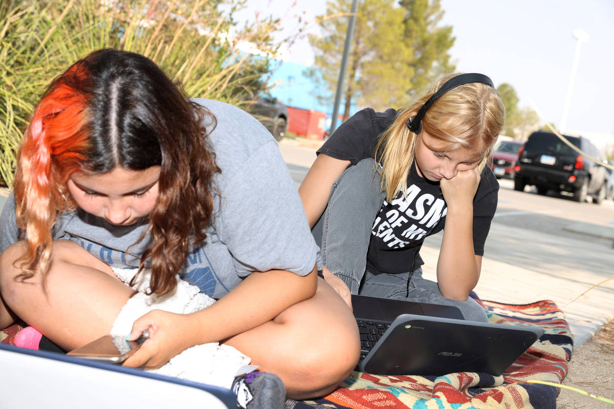 Imogen Dedmon, 15, left, and her sister Shayne, 13, participate in their virtual classes using ...