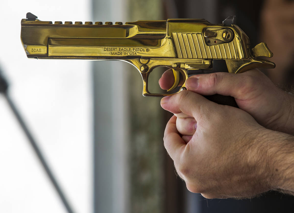 Adrenaline Mountain owner and CEO Eric Brashear readies to fire a titanium gold Desert Eagle pi ...