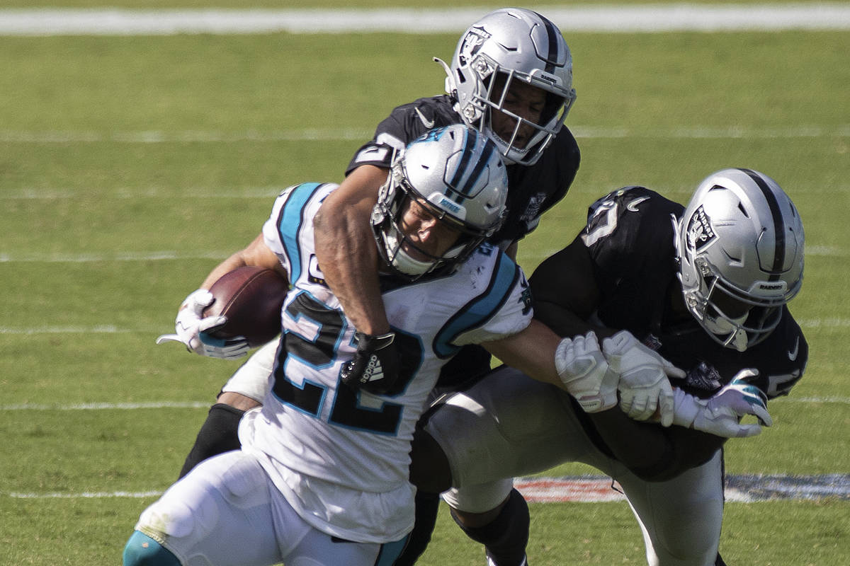 Carolina Panthers running back Christian McCaffrey (22) is tackled by Las Vegas Raiders safety ...