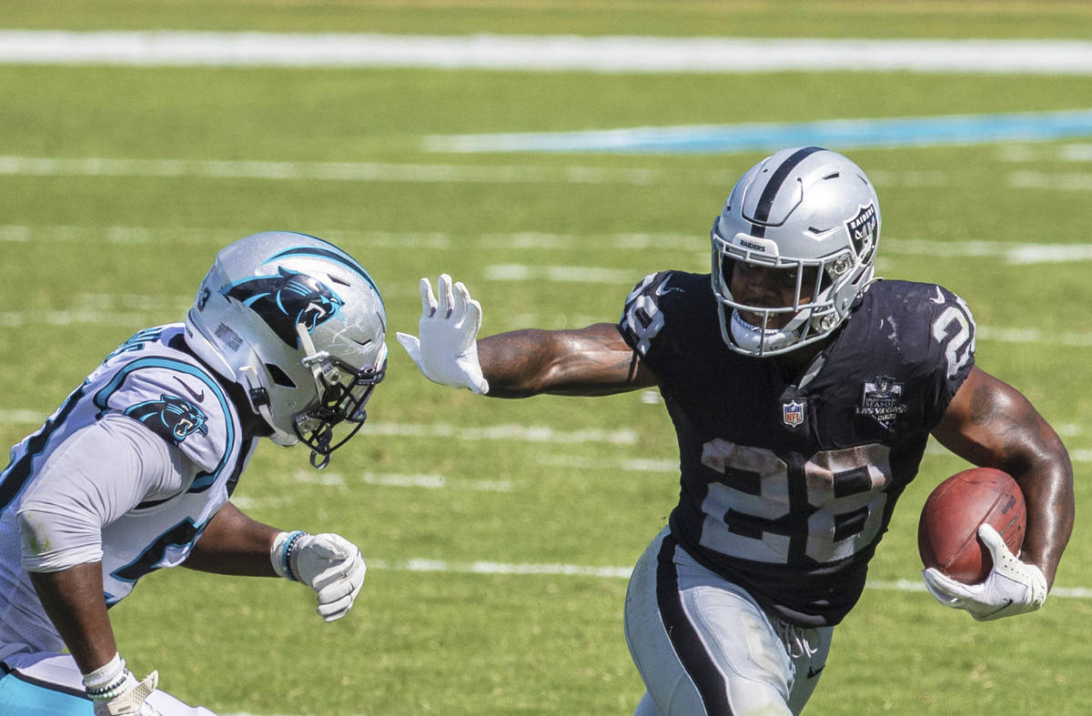 Las Vegas Raiders running back Josh Jacobs (28) stiff arms Carolina Panthers linebacker Brian B ...