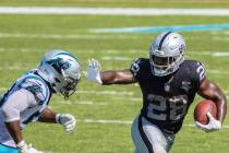 Las Vegas Raiders running back Josh Jacobs (28) stiff arms Carolina Panthers linebacker Brian B ...