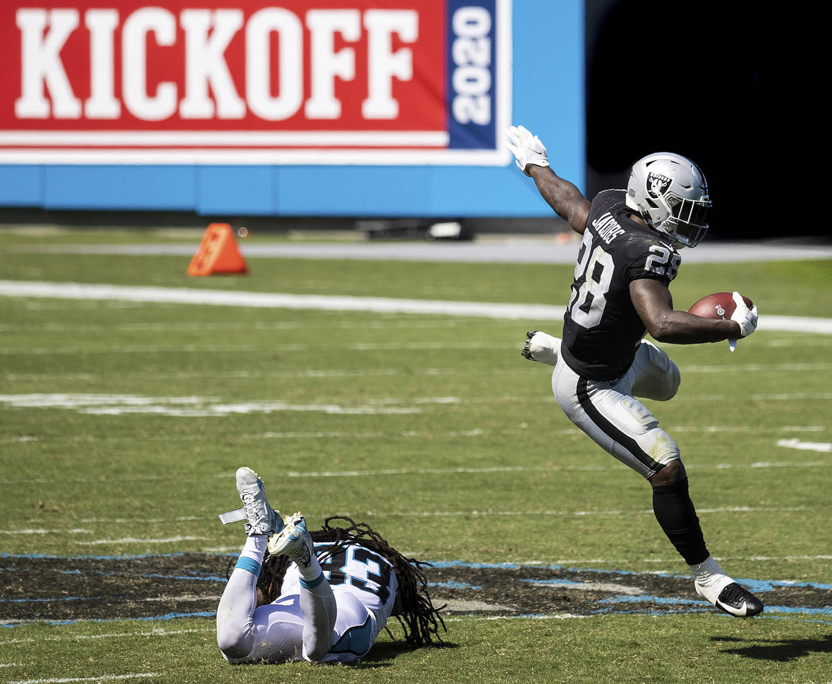 Las Vegas Raiders running back Josh Jacobs (28) leaps over Carolina Panthers safety Tre Boston ...