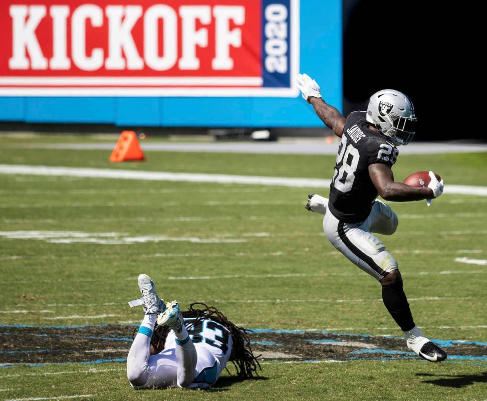 Las Vegas Raiders running back Josh Jacobs (28) leaps over Carolina Panthers safety Tre Boston ...