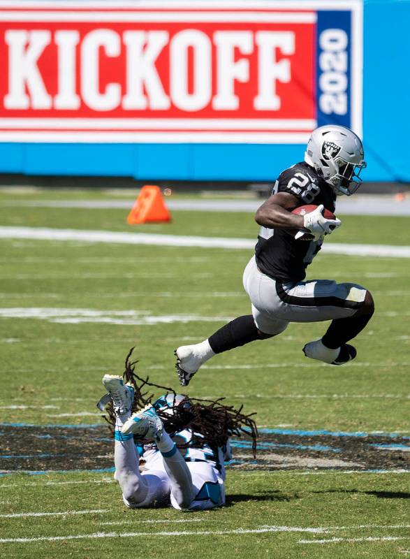 Las Vegas Raiders running back Josh Jacobs (28) leaps over Carolina Panthers safety Tre Boston ...