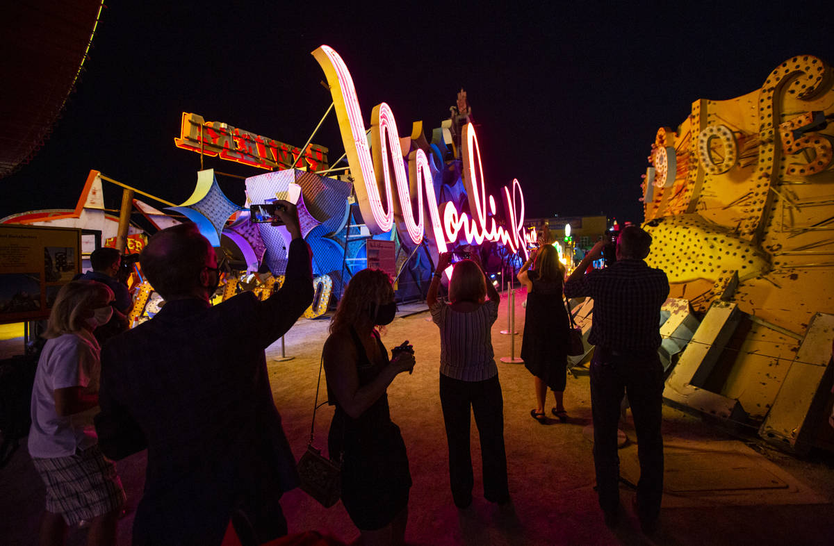 People take photos as the Moulin Rouge sign is reilluminated at the Neon Museum in Las Vegas on ...