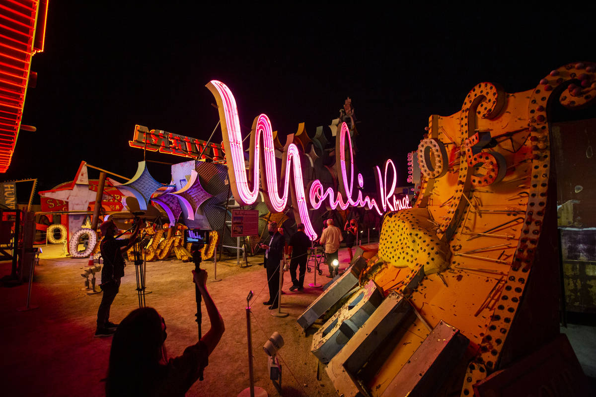 People take photos and record video as the Moulin Rouge sign is reilluminated at the Neon Museu ...