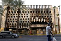 A pedestrian walks past the 4 Queens hotel-casino parking garage where at least five vehicles c ...