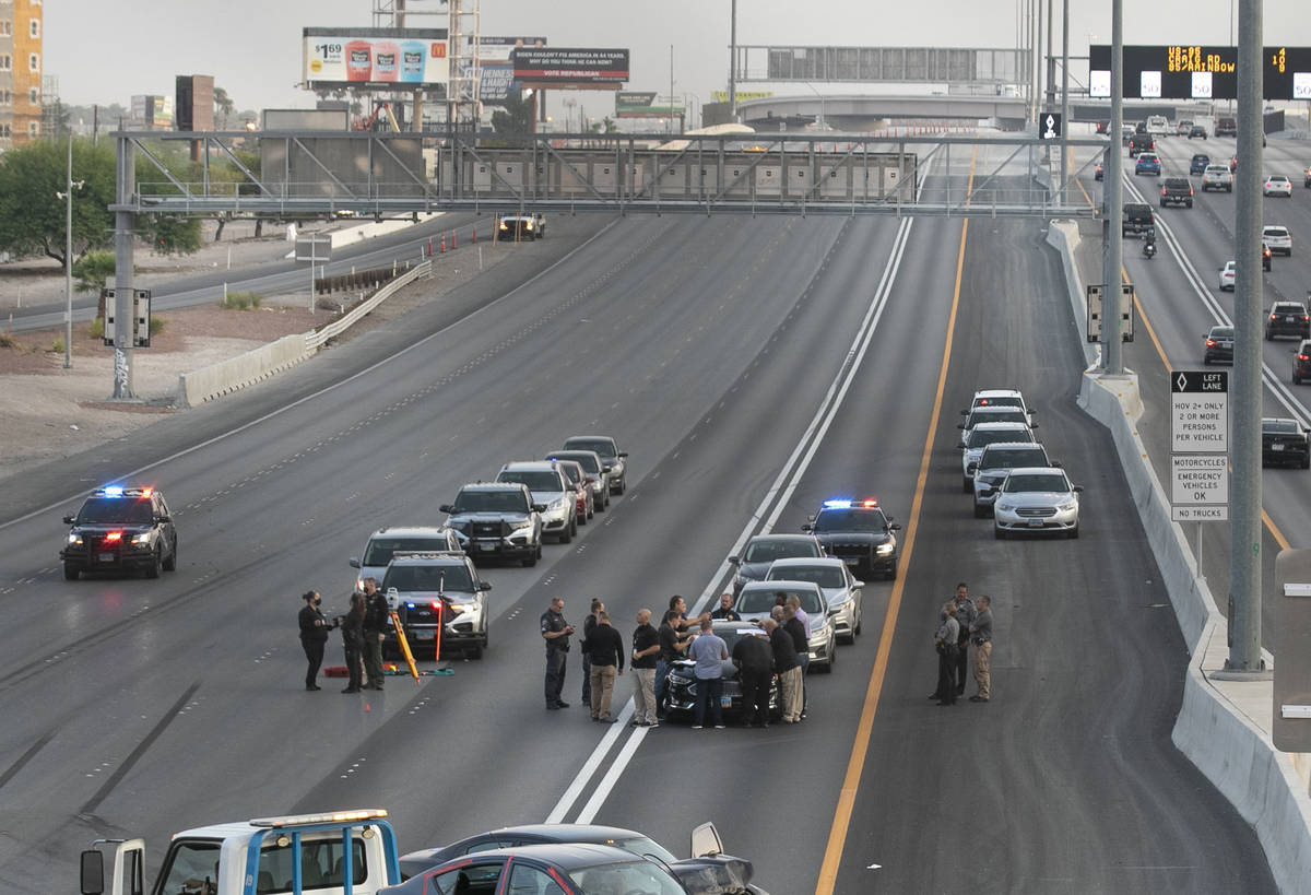 A team of officers and detectives investigate a fatal crash involving a shooting on southbound ...